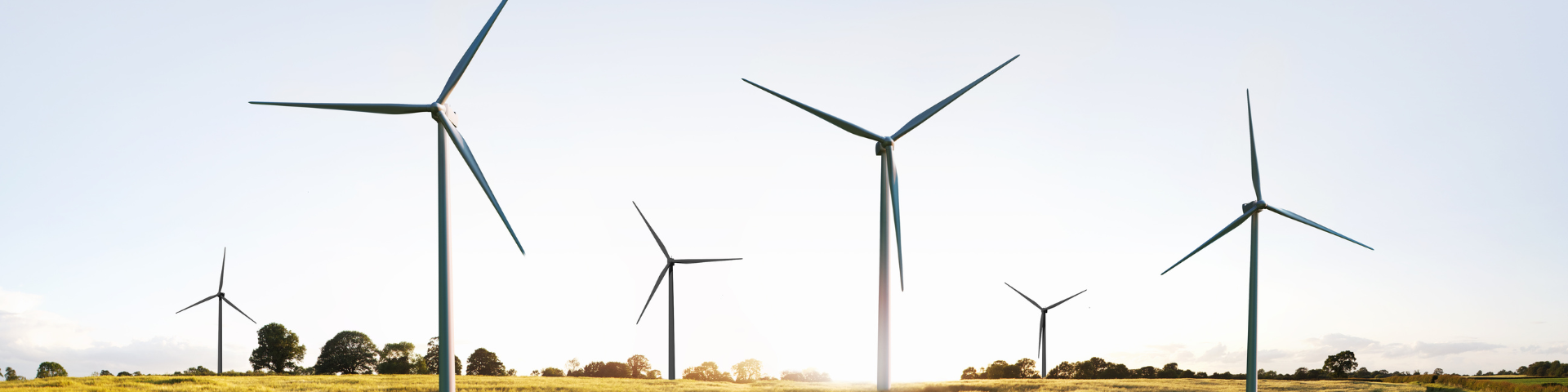 Wind turbines against a blue sky and setting sun