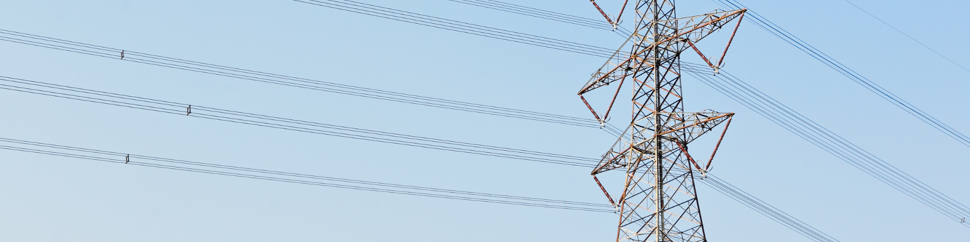 Transmission tower and power lines against a blue sky