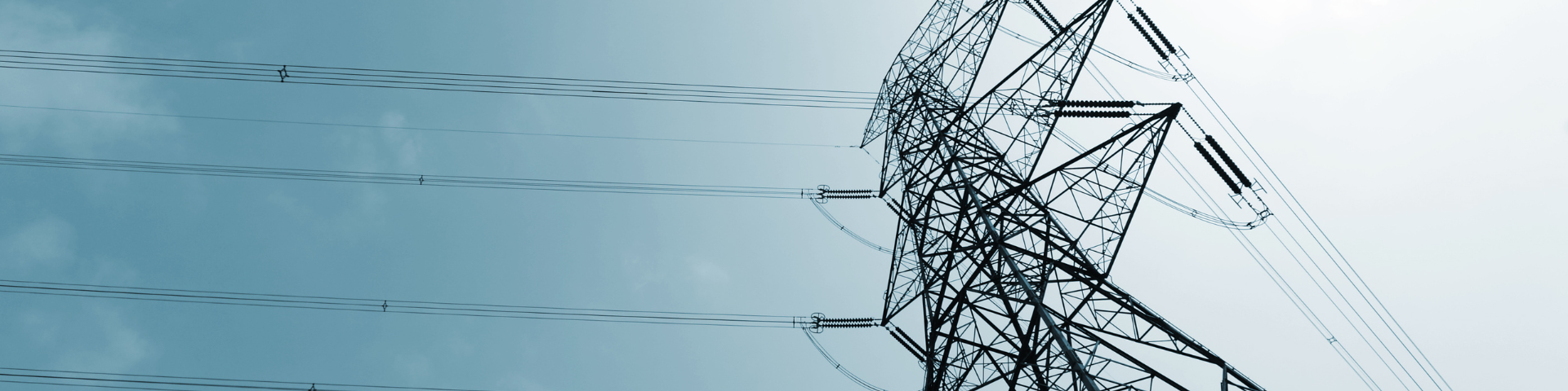 Transmission lines viewed from the ground against a blue sky